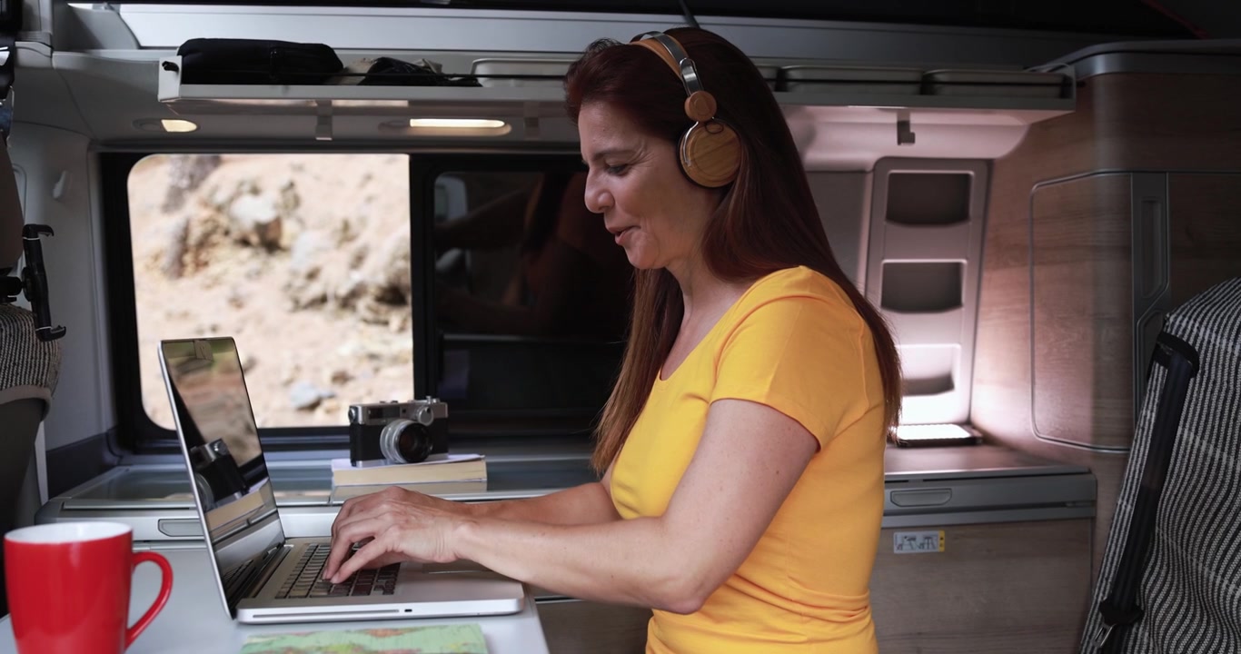 Woman Working on Laptop Inside a Camper Van