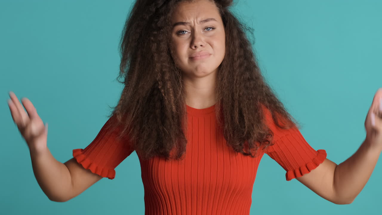 Upset Caucasian curly haired woman in front of the camera.