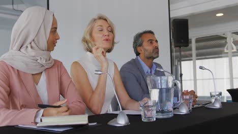 a panel of business delegates talking at a conference