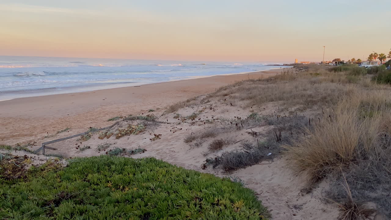 sunrise soft light paints the dunes of El Palmar while Atlantic waves roll in, capturing the calm before another surf session