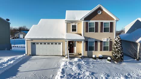 beige colored house with garage in winter snow