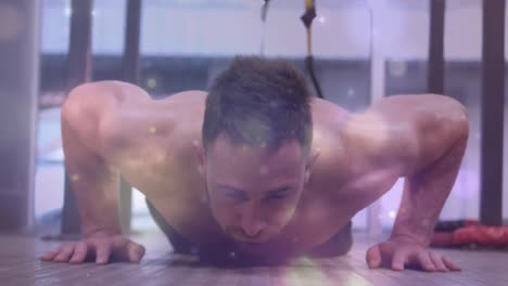 animation of light spots over muscular man exercising in gym