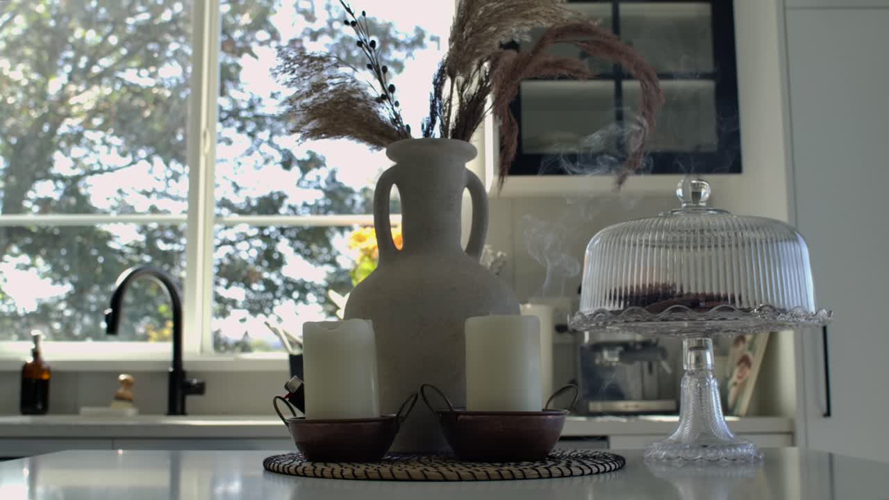 Woman Blows Out Candles on Kitchen Table - Interior Design Static Shot