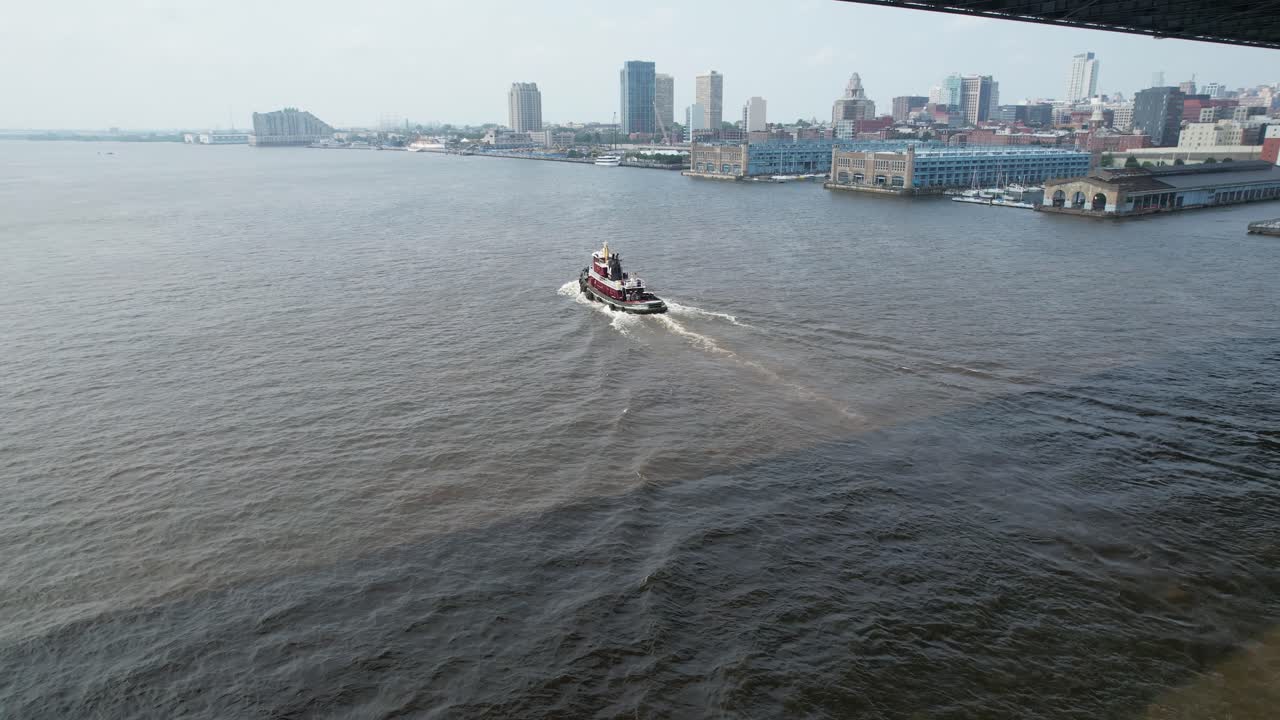 Tug boat on delaware river drone chases under ben franklin bridge on summer day
