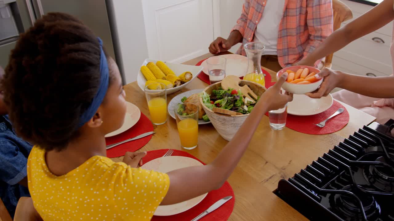 High angle view of happy black family eating food on dining table in a comfortable home 4k