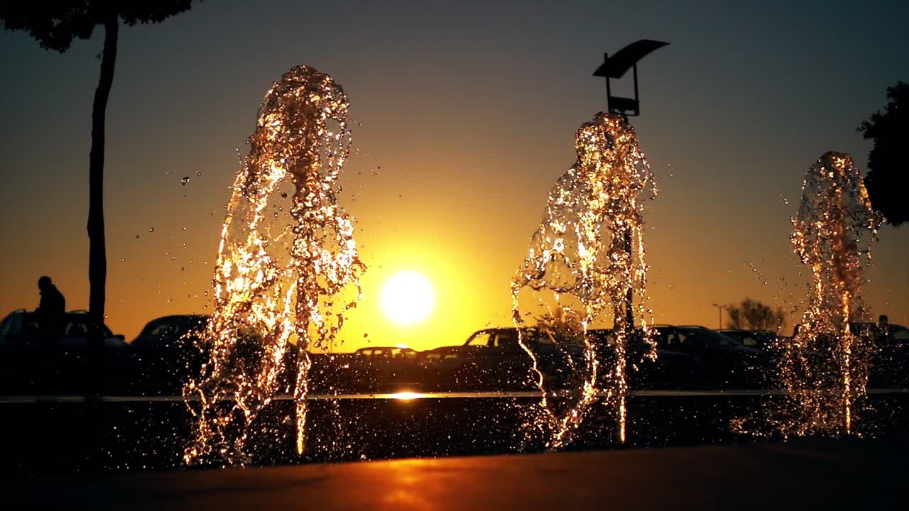 해가 지는 도시에서 물 분수 느린 동작