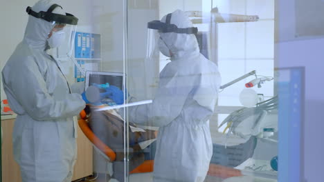 equipo de dentistas de pie cerca del paciente hablando