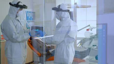 team of dentists standing near patient talking