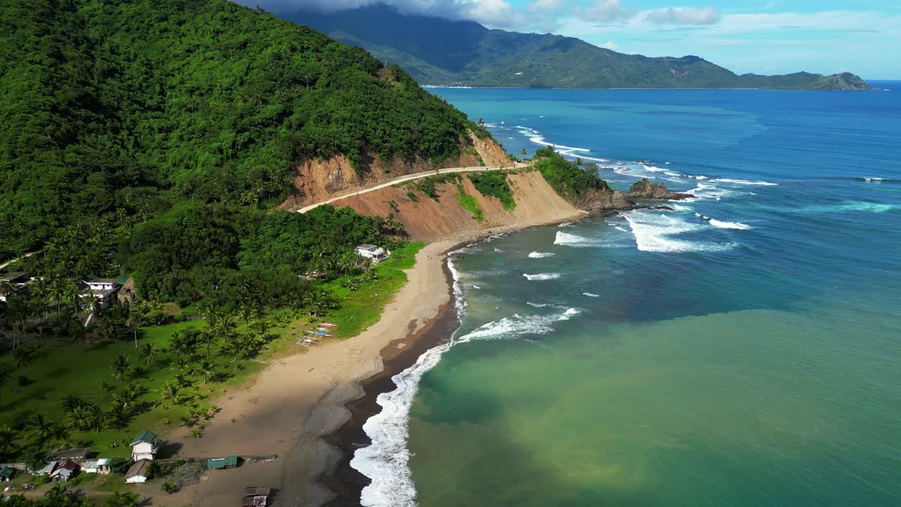 Elevated view focusing on the hillside road in Dingalan, Aurora, winding above bright yellow slopes as turquoise waves crash powerfully against the rugged coastline below