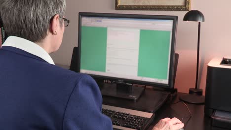 Over-the-shoulder-view-as-an-older-woman-uses-the-computer