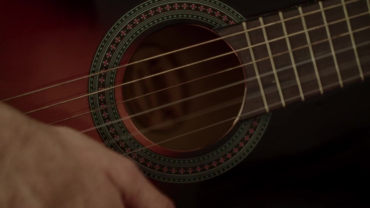 A detailed closeup shot of a musicians hand strumming a classic acoustic guitar, capturing authentic movement and artistic expression.