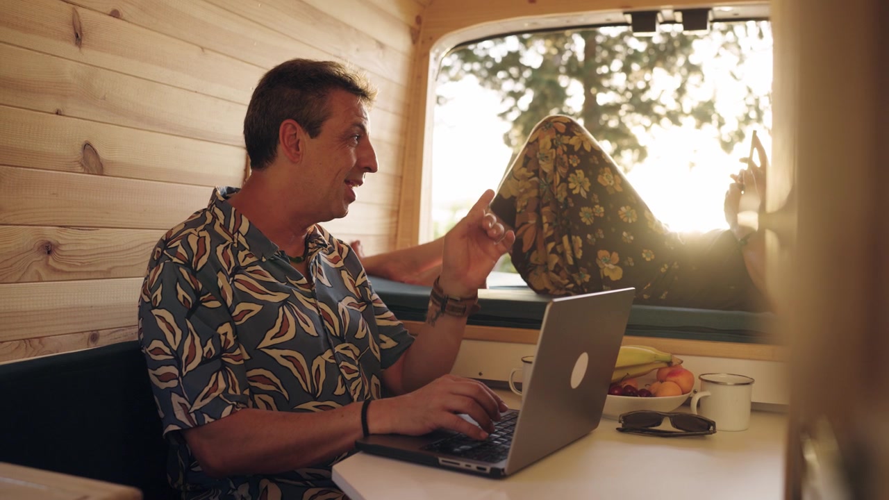 Man Working on Laptop Inside a Camper Van