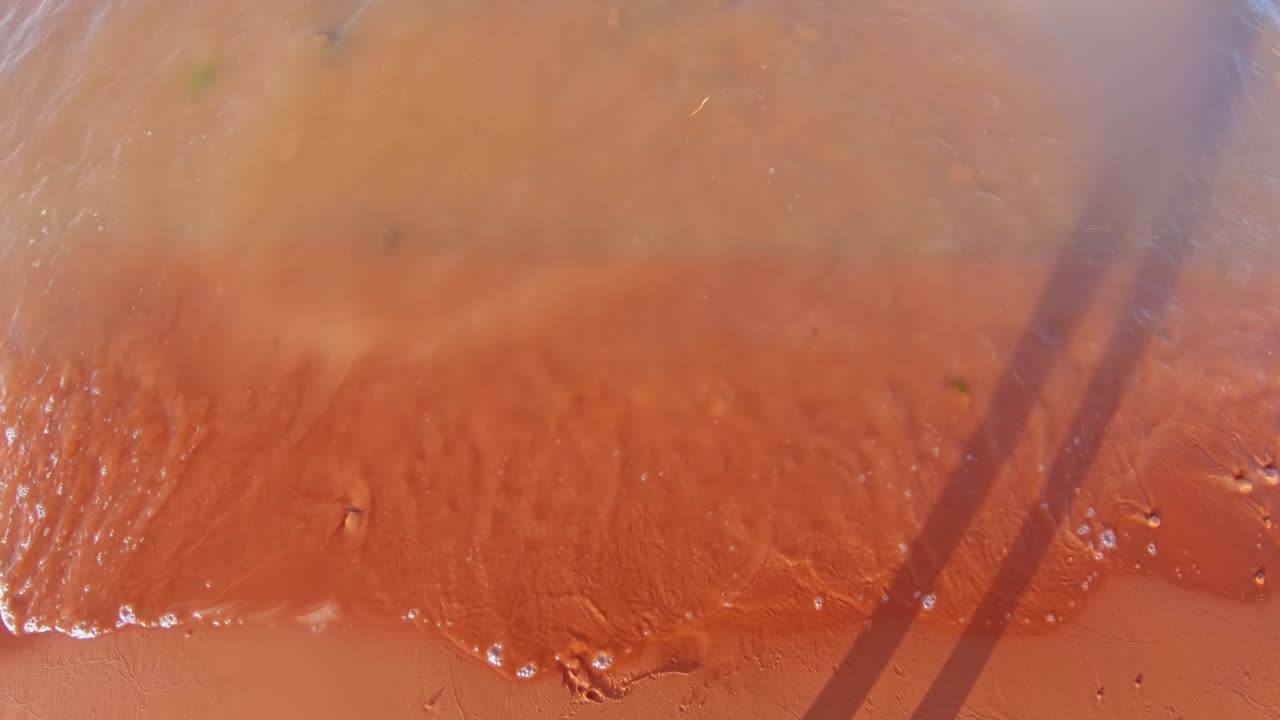 따뜻한 화창한 여름날 남부 유타에 있는 붉은 모래 모래 속이 빈 주립 공원 호수 저수지 해안으로 들어오는 작은 파도의 느린 동작 하향식 전망