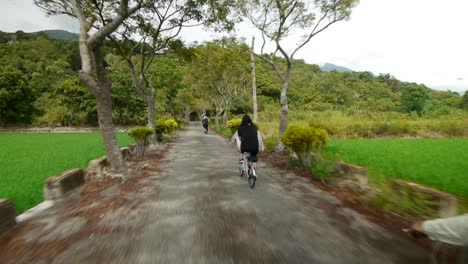 女單車騎手在鄉村的小單車土地上騎單車,從後面拍攝,攝影機通過單車者