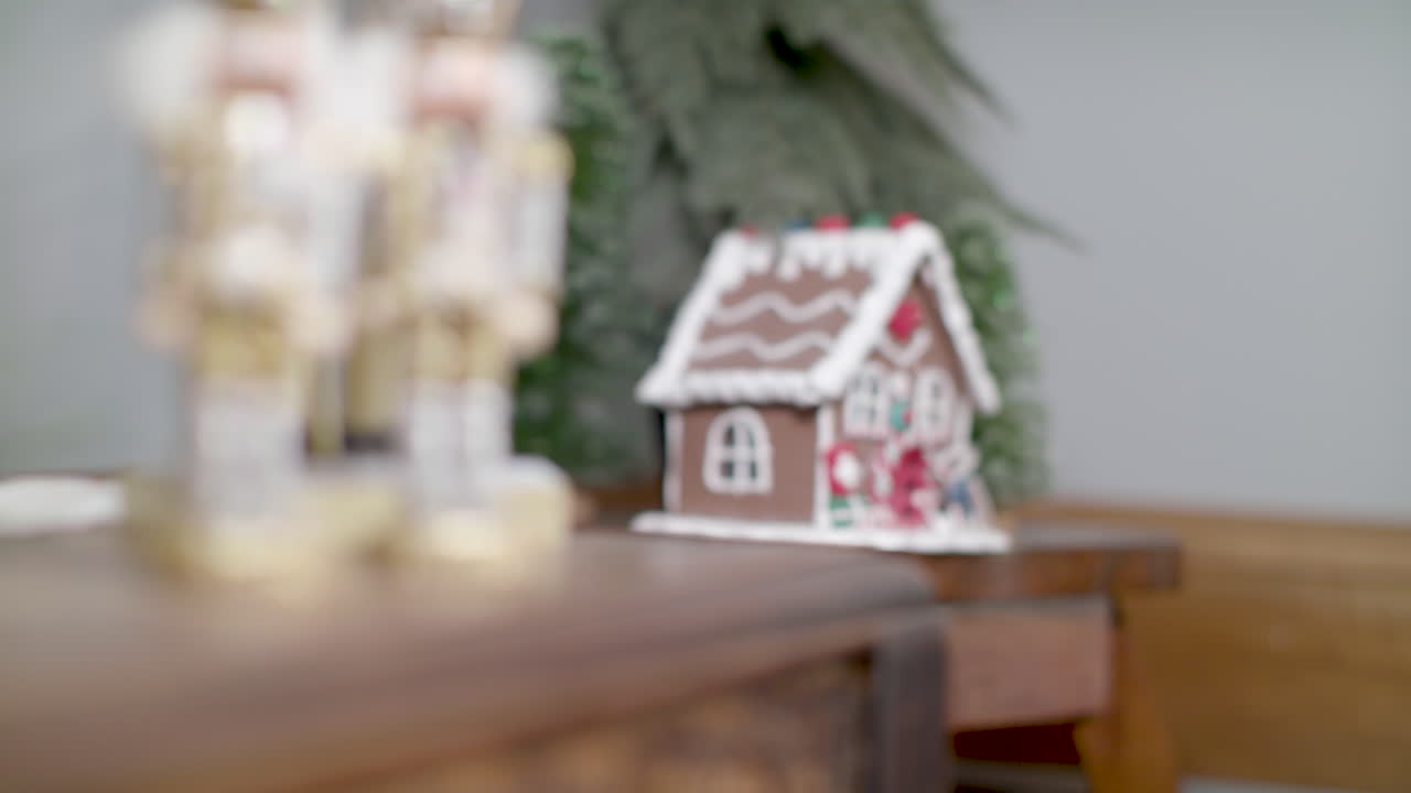 A pair nutcrackers and a gingerbread house sit on top of tables as decoration for the Christmas holiday season