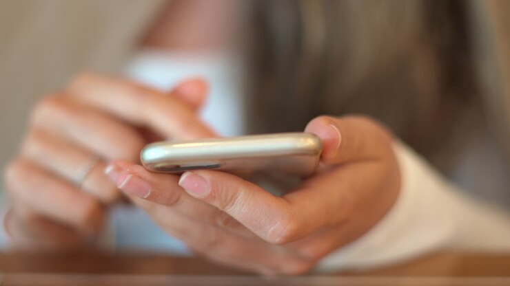 Close up of a woman scrolling through her phone at a restaurant