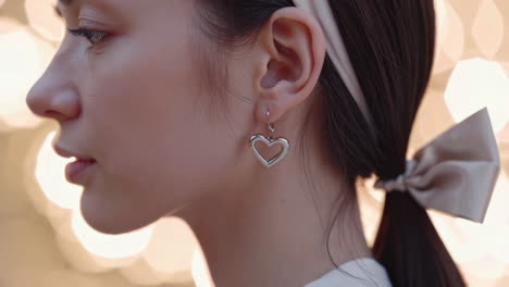 close-up of a woman wearing a heart-shaped earring