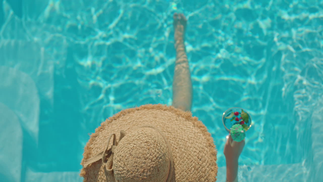 Woman Relaxing in a Pool with a Cocktail