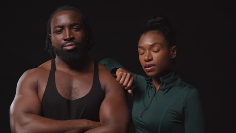 retrato de estudio de determinados atletas masculinos y femeninos entrenando en ropa de fitness disparado contra un fondo negro 3