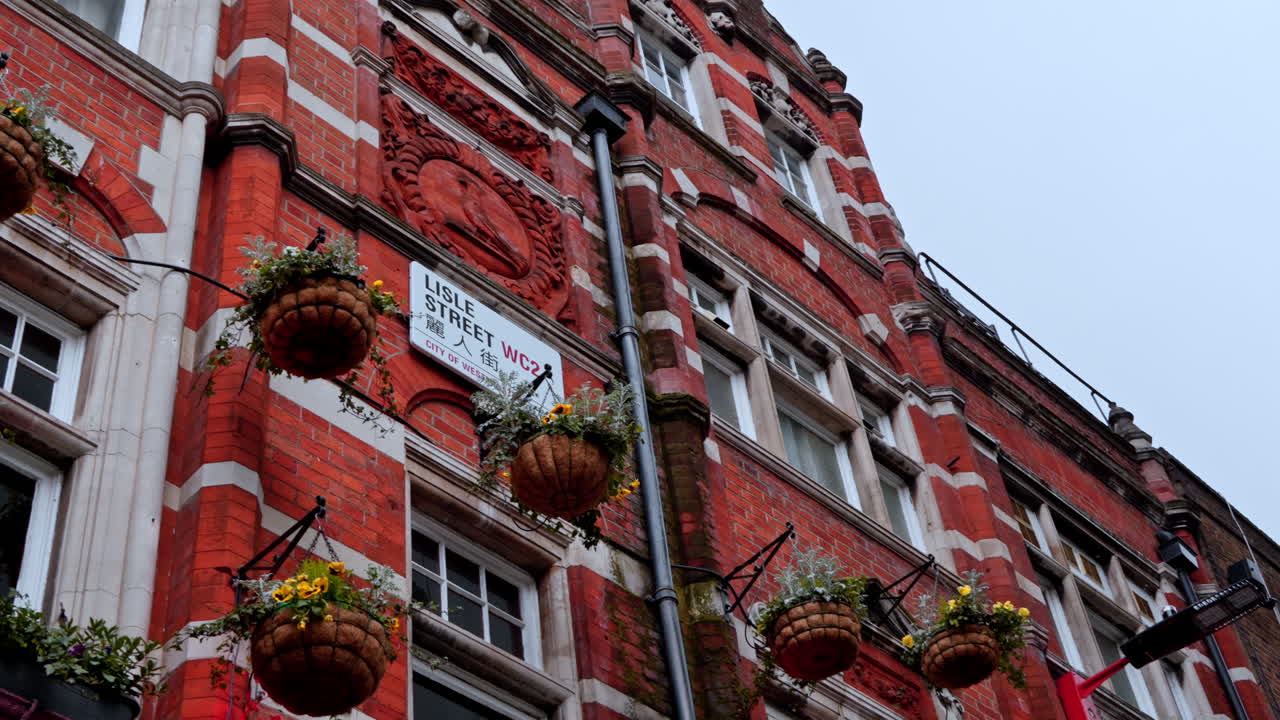 Vibrant brick facade in London's Chinatown with hanging flower baskets
