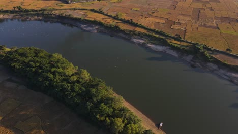 Un-Video-Aéreo-Impresionante-De-Un-Río,-Que-Sirve-Como-Una-Fuente-De-Agua-Vital-Para-Las-Tierras-De-Cultivo-Cercanas