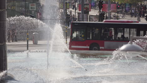telephoto slomo view of traffic around fountain spraying water at sergels square