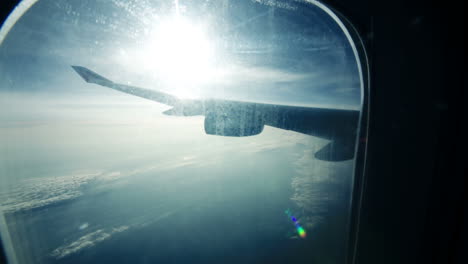 Vista-Panorámica-De-Las-Nubes-Y-El-Ala-Del-Avión-Desde-El-Iluminador