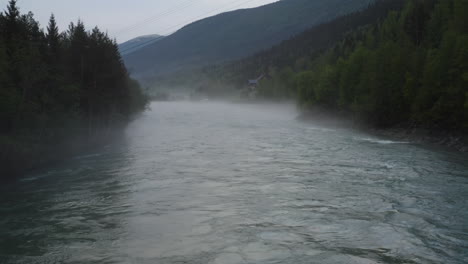 flight over a foggy river. the mist is hanging low over the landscape creating a dark mystical mood over the whole scene.