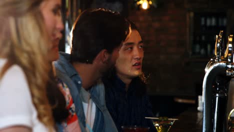 Friends-enjoying-drink-at-bar-counter