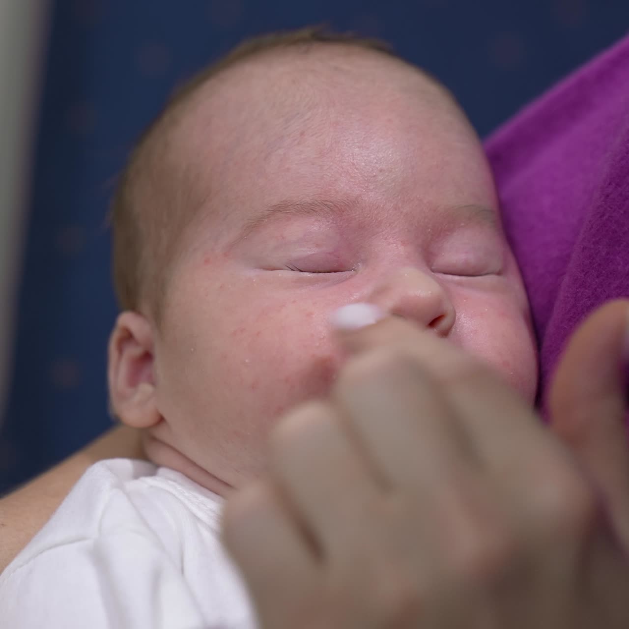 Mother is touching gently baby's forehead, nose and cheeks. Adorable toddler is sleeping tightly and doesn't wake to wake up. Close up