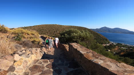una familia camina por un pequeño camino de piedra