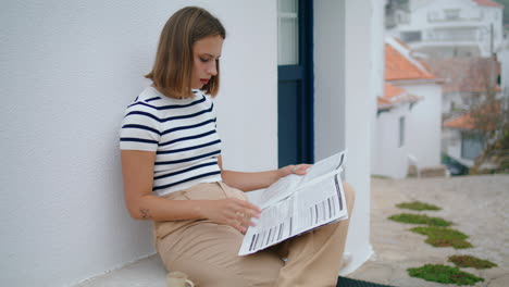 Schönes-Mädchen,-Das-Auf-Der-Straße-Zeitung-Liest.-Konzentrierter-Reisender,-Der-Kaffee-Trinkt