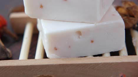 white handmade soap bars on wooden soap dish