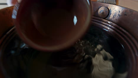 wide angle close up of the water surface in the water bucked used in the sauna called a kip or pail