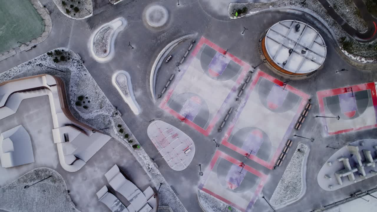 пустые заснеженные спортивные площадки и пандусы для катания на коньках в городском парке