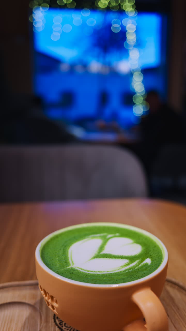 Close up of a matcha latte on a wooden tray at a cafe. Vertical