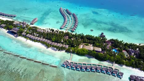 bungalows sobre aguas turquesas de la laguna alrededor de una isla tropical, conectados por muelles de madera con playas de arena blanca y bares restaurantes en bora bora