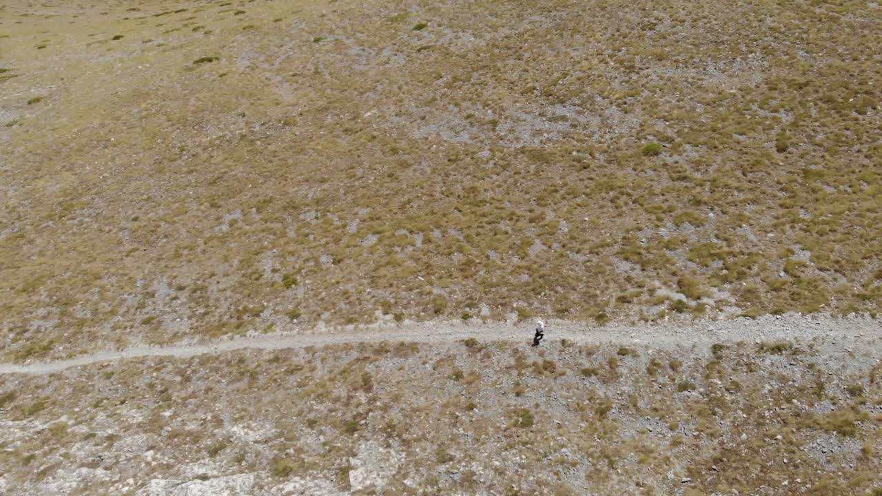 toma aérea de un hombre caminando, caminando solo en la montaña griega kissavos en la región de tesalia, vista de drones, ruta en la montaña, estilo de vida deportivo, manera saludable de dejar el paisaje marrón
