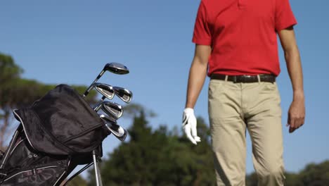 male golfer removing golf club from golf bag