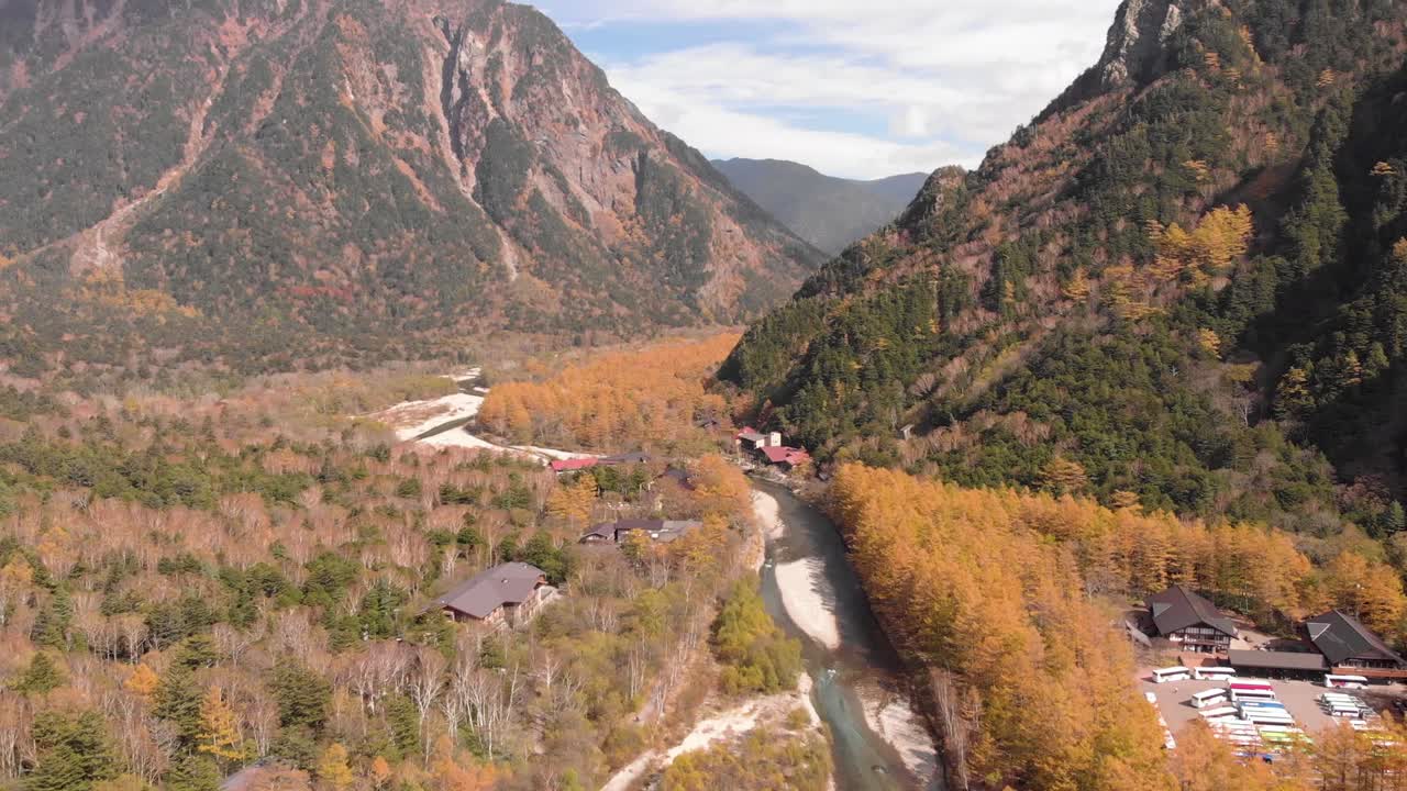 화창한 날 3일에 주황색 숲 생활과 맑고 푸른 물과 하늘이 있는 가을 달 동안 광대한 가미코치 숲 풍경의 영화 같은 공중 드론 샷