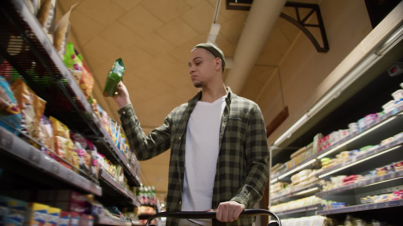 식료품 가게에서 혼합 인종의 남자가 무작위로 카트에 물건을 넣었습니다.