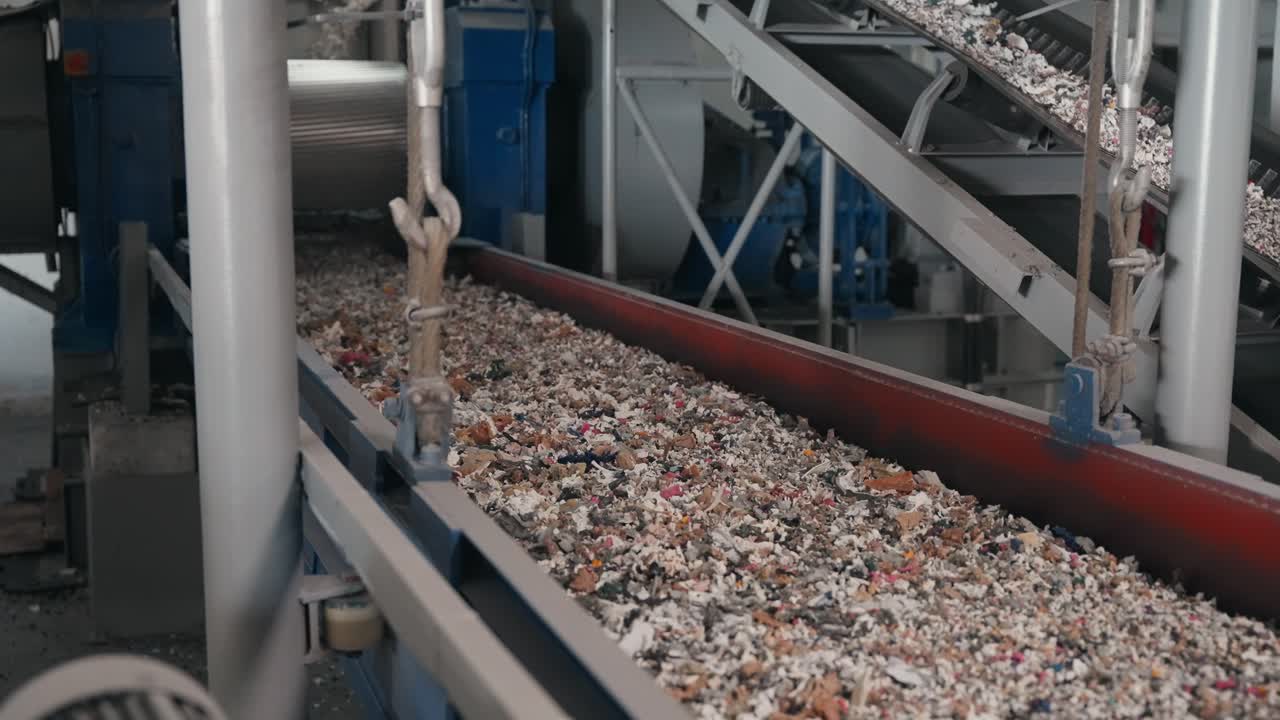 Fragmentos de residuos mezclados que se desplazan a lo largo de una línea de transporte de una fábrica