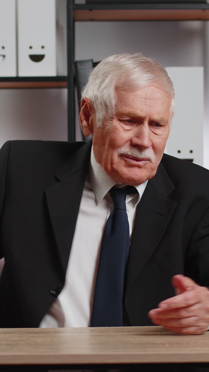 empresario senior conmocionado abriendo un sobre leyendo malas noticias en una carta se siente molesto en la mesa de la oficina