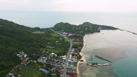 tropical lagoon and township on coastline of thailand, aerial view