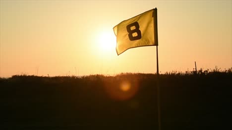 Bandera-De-Golf-Al-Atardecer-Con-Rayos-De-Sol