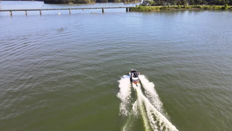 Wake-Boarding-Boot,-Das-Sich-Keiner-Wake-Zone-Nähert-Und-Unter-Einer-Brücke-Hindurchfährt