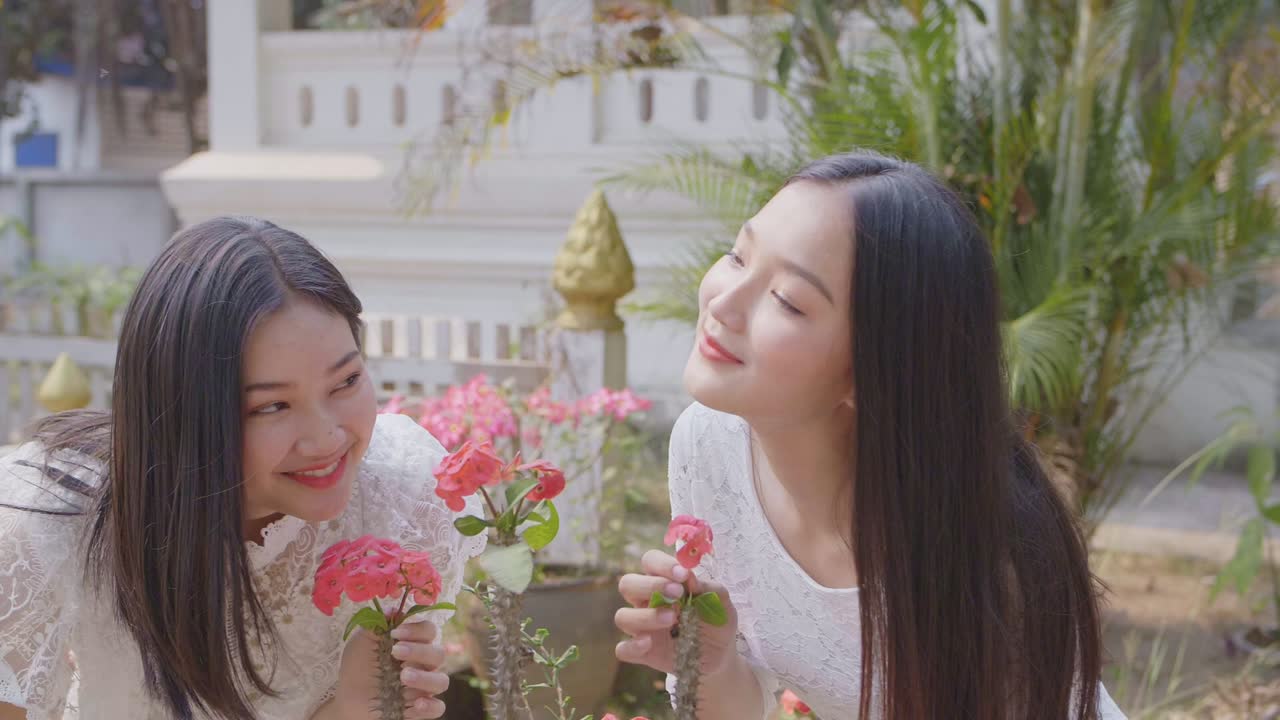 Two Girls Smelling Red Flowers, Slow Motion