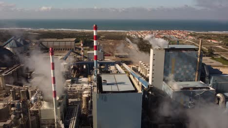 drone shot of industrial zone with thick smog and burning fossil fuels