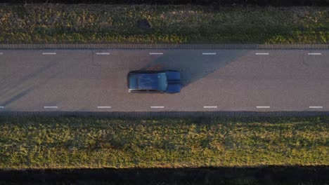 Oben-Drohnenaufnahme-Eines-Autos,-Das-Eine-Straße-Entlangfährt