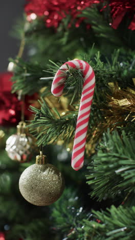 vertical video of christmas tree with candy cane and decorations and copy space